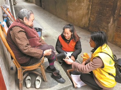 社工与义工为服务对象试穿爱心人士捐赠的新鞋子。