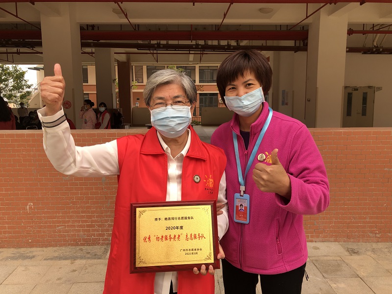 图2：张特加老人作为代表领取黄播
2020年度优秀“初老服务老老”志愿服务队牌匾.jpg