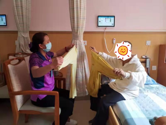 图2:护理员引导老人自主叠衣服.jpg