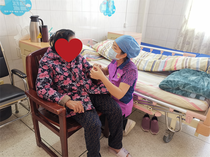 图3:阿娣在给隔离老人按摩手指.jpg